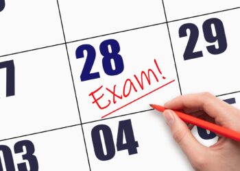 Takvim yaprağı üzerinde 28 tarihi ve kırmızı kalemle atılmış exam yazısı.