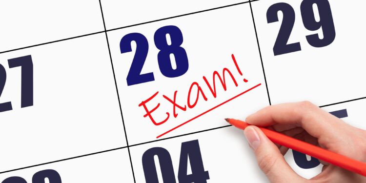 Takvim yaprağı üzerinde 28 tarihi ve kırmızı kalemle atılmış exam yazısı.