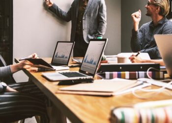 Ofis ortamında masa başında bilgisayarla çalışan profesyonel iş insanları.