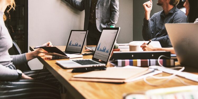 Ofis ortamında masa başında bilgisayarla çalışan profesyonel iş insanları.