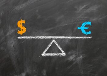 Kara tahta üzerine tebeşirle çizilmiş terazi üzerinde dolar ve euro sembolleri.