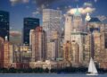 Manhattan silüeti ve gökdelenlerin önünde süzülen yelkenli tekne.