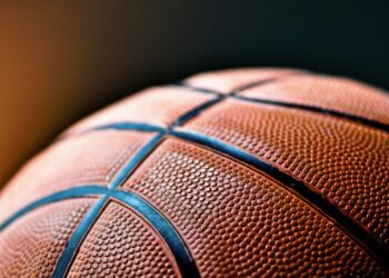 Yakın plan çekimde turuncu renkli basketbol topunun siyah çizgileri görünüyor.