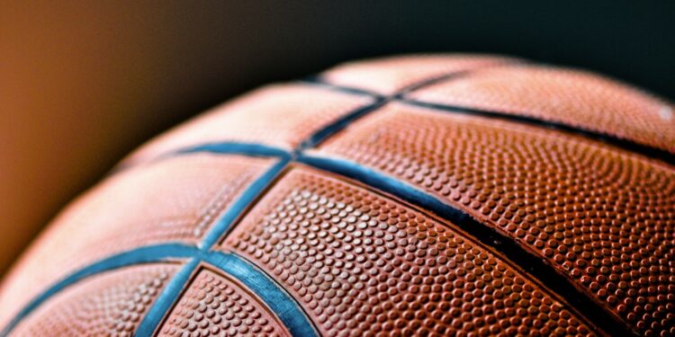 Yakın plan çekimde turuncu renkli basketbol topunun siyah çizgileri görünüyor.