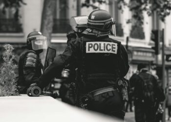 Fransa'da sokak gösterilerinde görev yapan çevik kuvvet polisleri ve arkalarındaki kalabalık.