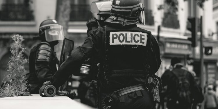 Fransa'da sokak gösterilerinde görev yapan çevik kuvvet polisleri ve arkalarındaki kalabalık.