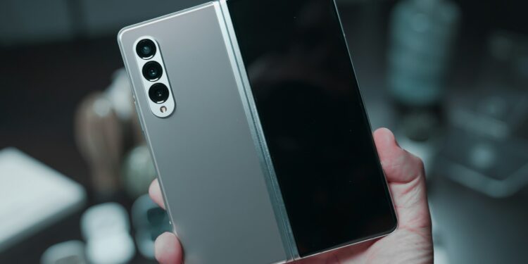 Elde tutulan gri renkli katlanabilir akıllı telefonun dış ekranı ve kameraları görülüyor.