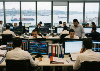 Modern bir ofiste çalışan ve ekranlardan finansal verileri takip eden borsa uzmanları.