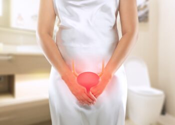 Kadın elleriyle alt karın bölgesini tutuyor, üzerinde mesane anatomisi çizimi var.