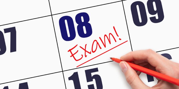 Takvim yaprağı üzerinde kırmızı kalemle sekizinci güne Exam yazan el.