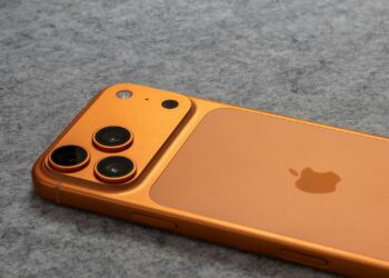 Turuncu renkli akıllı telefonun arka kapağı ve üçlü kamera modülü.