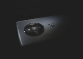 Karanlık bir zeminde yuvarlak kamera modülüne sahip siyah akıllı telefon.