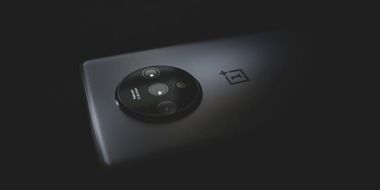 Karanlık bir zeminde yuvarlak kamera modülüne sahip siyah akıllı telefon.