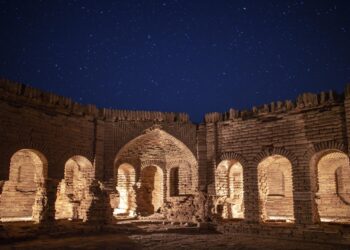 Gece vakti yıldızlı gökyüzü altında antik tuğla yapı kalıntıları.